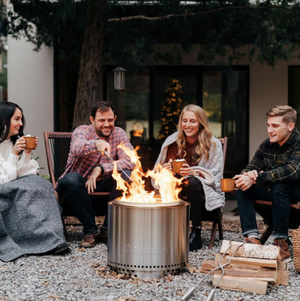 A photo of friends sitting around a bonfire.