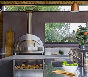 photo of a stainless steel pizza oven integrated with an outdoor kitchen.